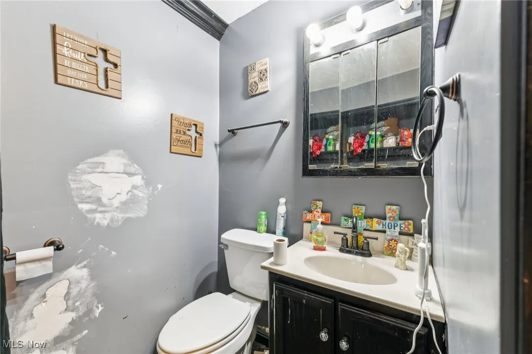Half bathroom featuring vanity and toilet