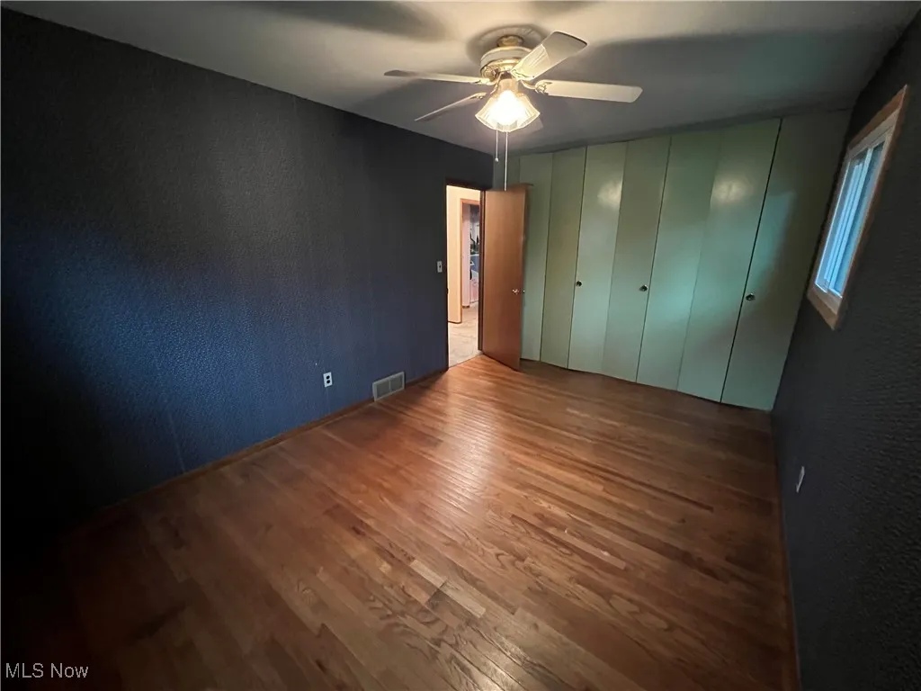 Unfurnished bedroom with wood finished floors and ceiling fan