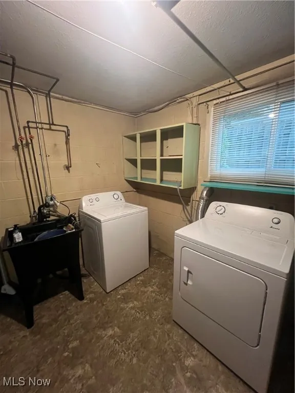 Laundry room with a textured ceiling and washer and dryer
