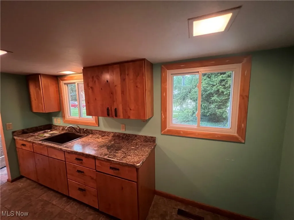 Kitchen with brown cabinets and dark stone counters
