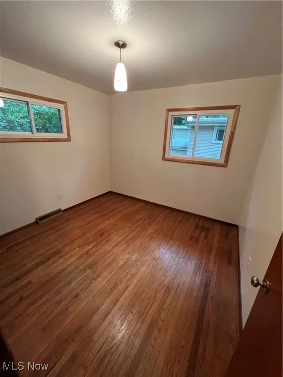 Spare room with hardwood / wood-style floors and a textured ceiling