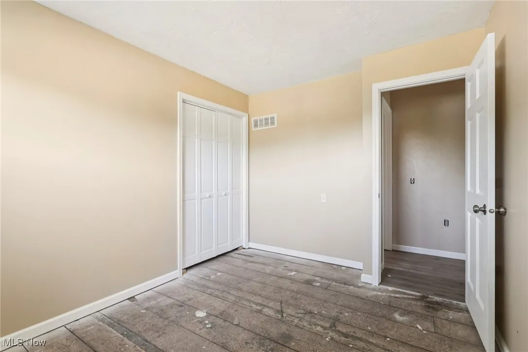 Unfurnished bedroom with hardwood / wood-style floors and a closet