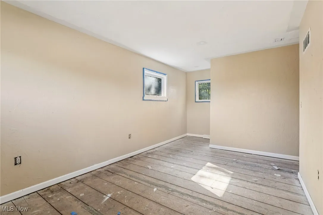 Spare room with baseboards and hardwood / wood-style floors