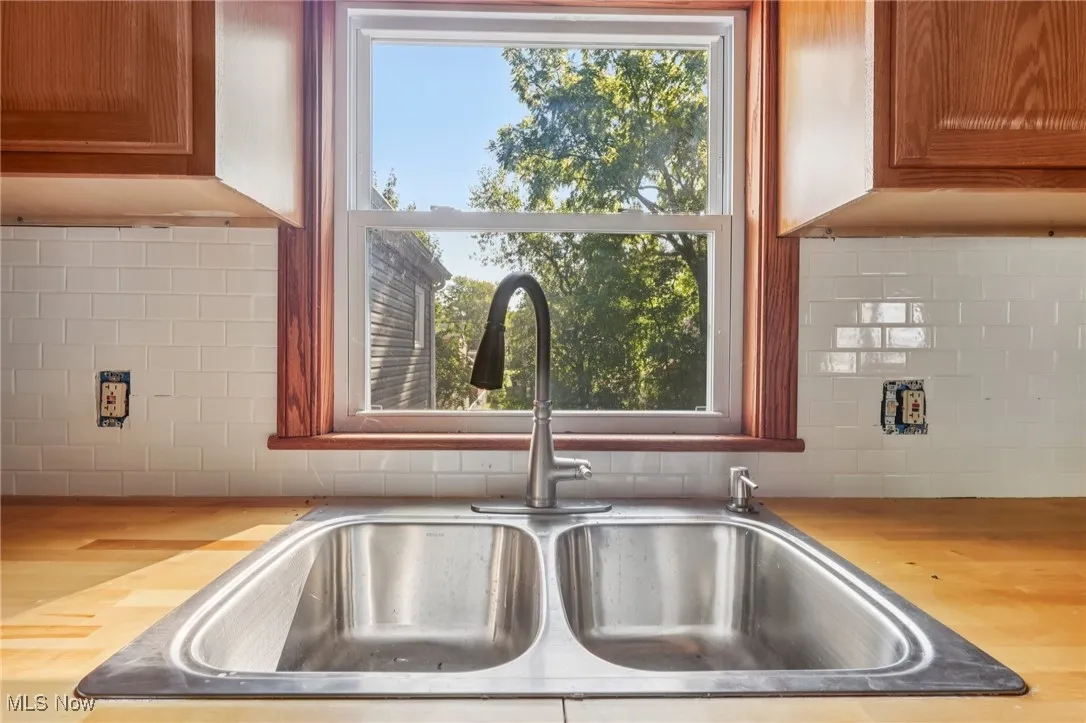 Kitchen view of wood counters, backsplash, and brown cabinetry