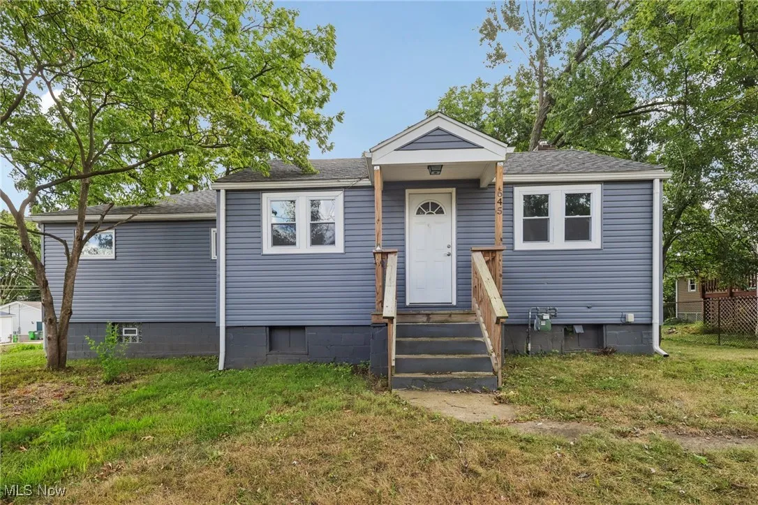 Bungalow-style home with a shingled roof and a front lawn
