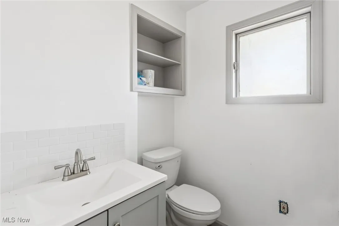 Bathroom featuring vanity and decorative backsplash