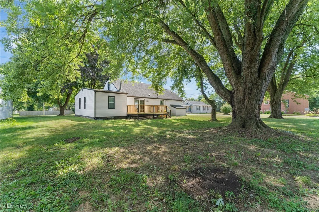 View of green lawn with a wooden deck