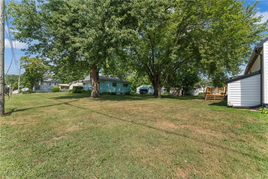 View of grassy yard with a deck