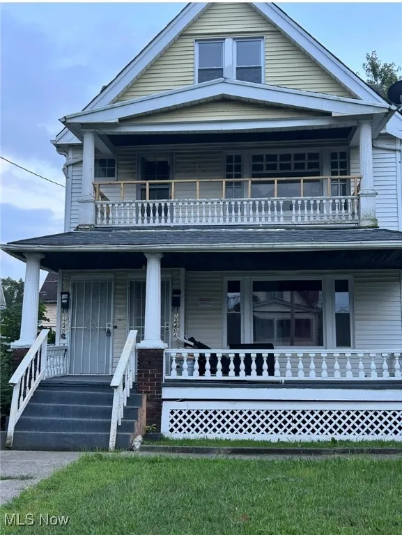 View of front of property with a porch and a front lawn