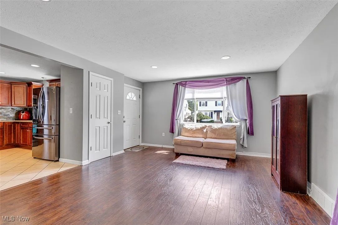 Living area featuring recessed lighting, light wood finished floors, and a textured ceiling