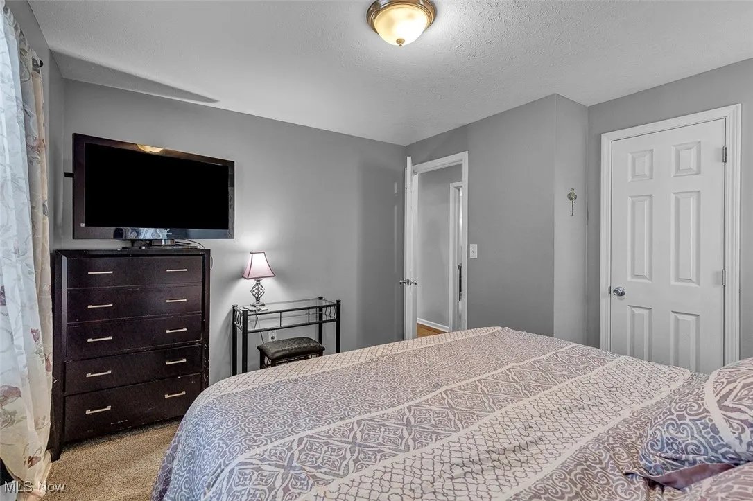 Bedroom featuring carpet flooring and a textured ceiling
