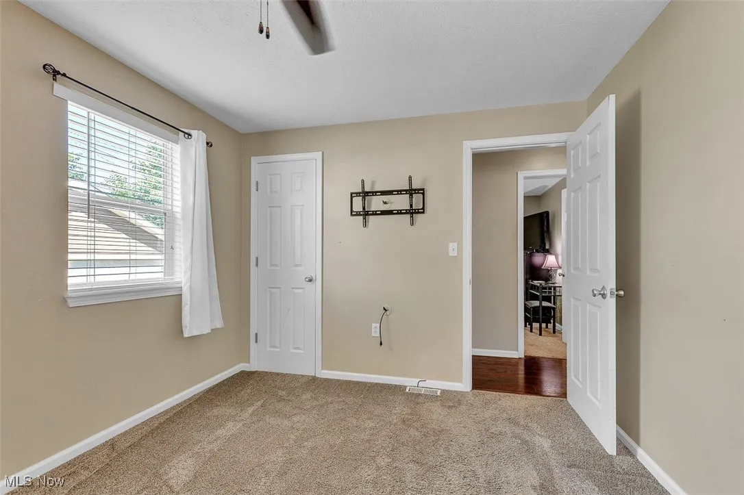 Unfurnished bedroom with carpet floors, ceiling fan, and a closet