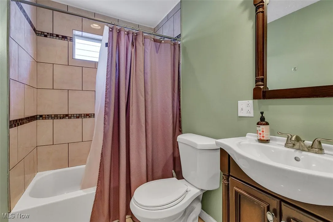 Full bathroom featuring shower / tub combo and vanity