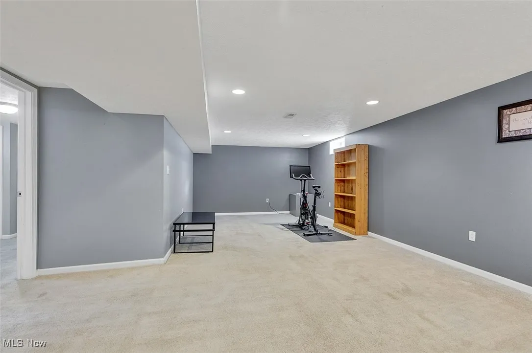 Exercise area with light colored carpet and recessed lighting