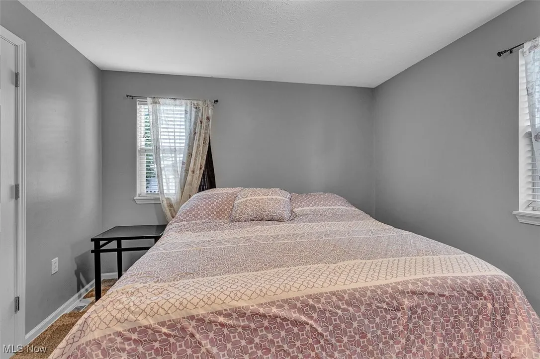 Bedroom featuring baseboards and a textured ceiling