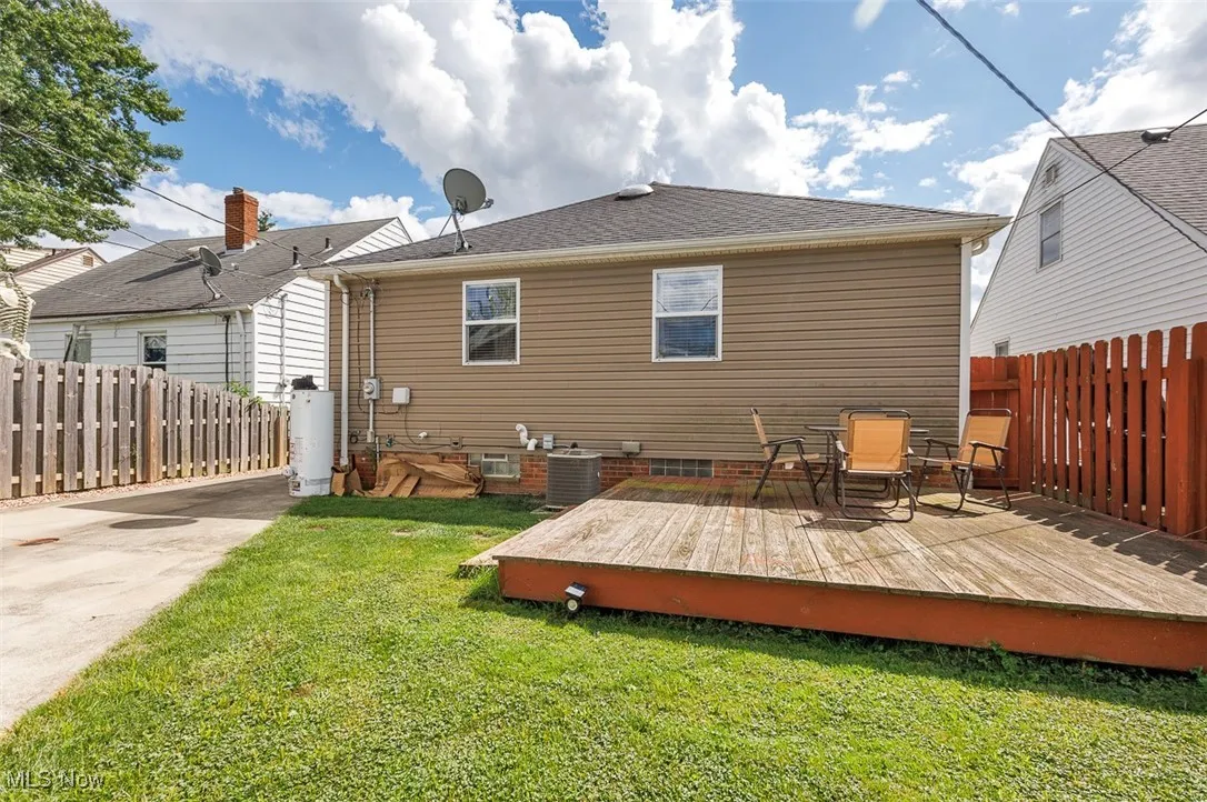 Back of property with a wooden deck and roof with shingles