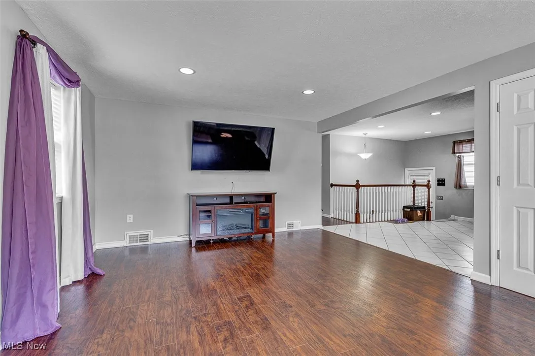 Living room with wood finished floors, recessed lighting, and a textured ceiling