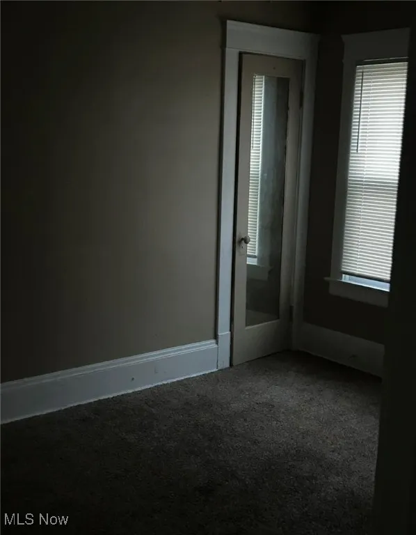 Unfurnished room featuring carpet and baseboards