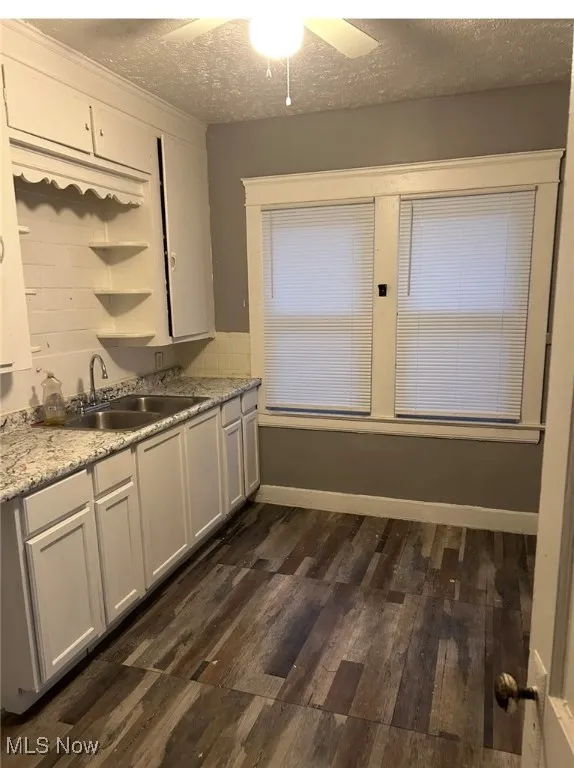 Kitchen with dark wood-style floors, a textured ceiling, white cabinetry, ceiling fan, and open shelves