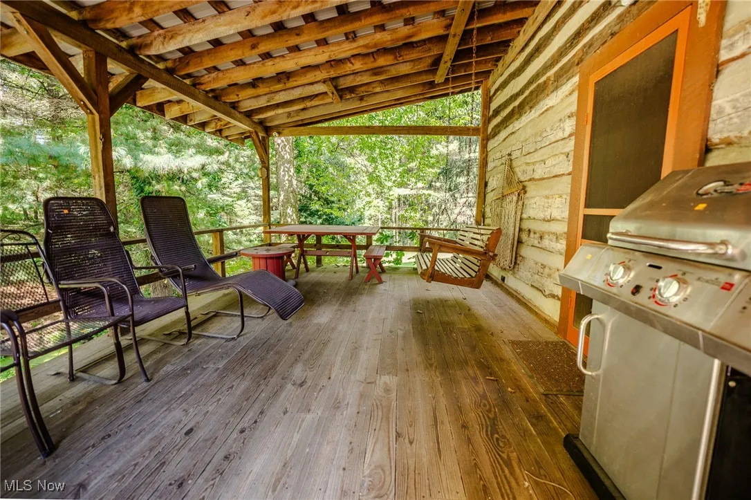 Wooden terrace featuring a grill