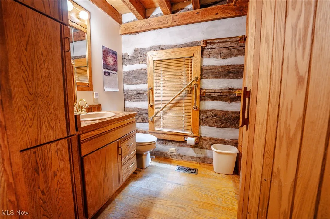 Bathroom featuring vanity, light wood-style floors, and beam ceiling