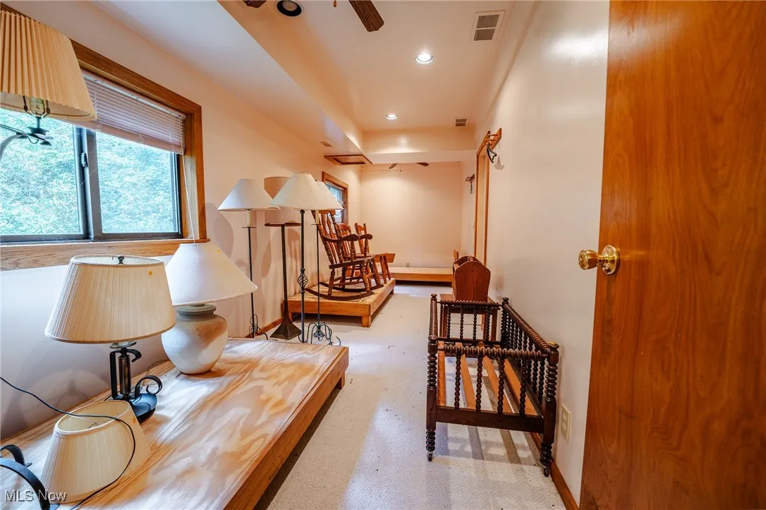 Hall with recessed lighting and light colored carpet