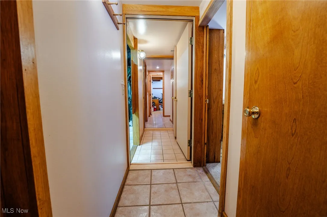 Hallway with light tile patterned floors and baseboards