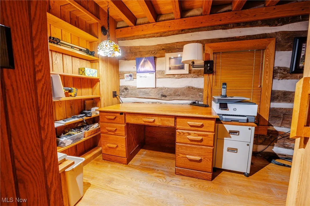 Office space featuring beam ceiling and light wood-style flooring