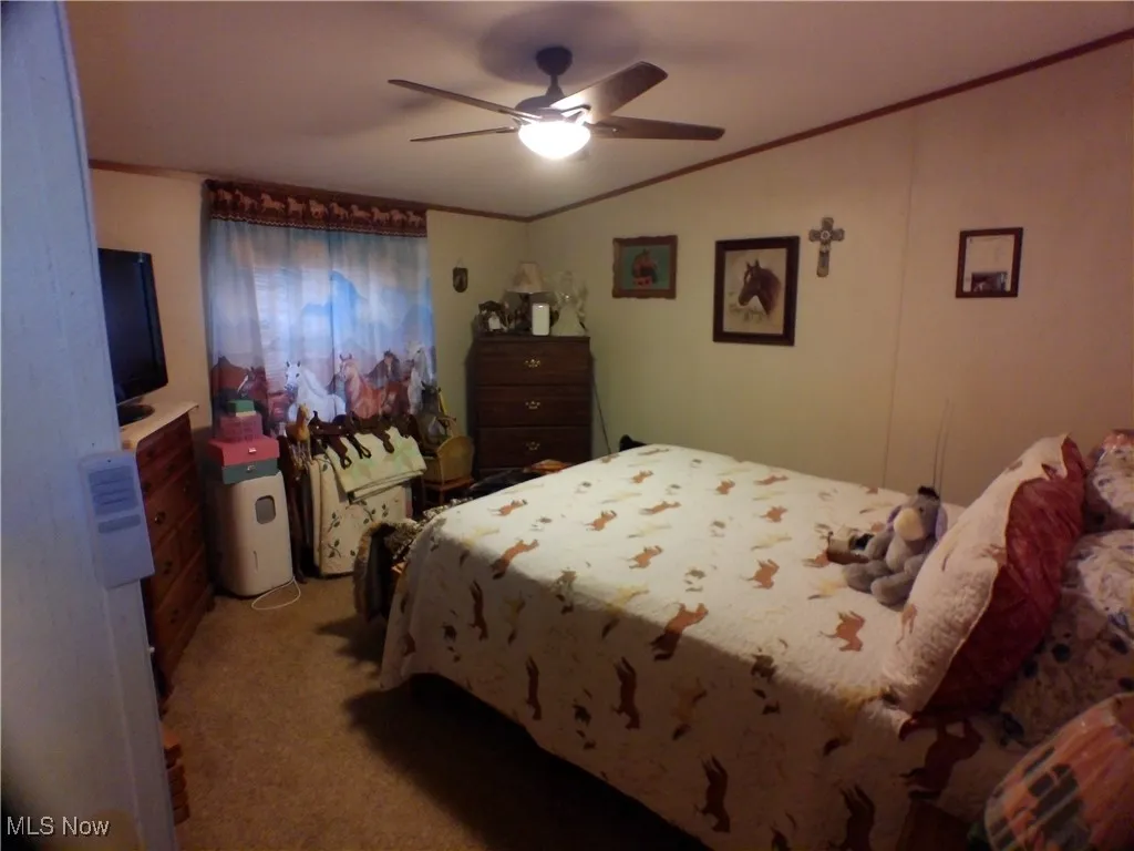 Bedroom with crown molding, light colored carpet, and ceiling fan