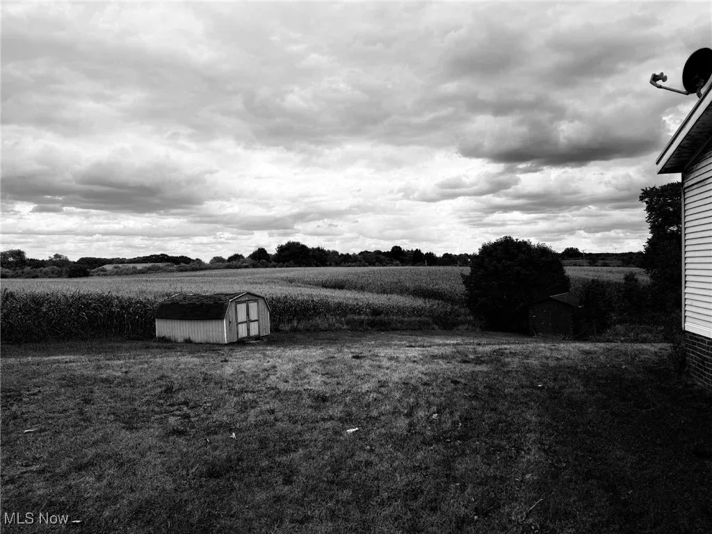 View of yard with a shed and a view of rural / pastoral area