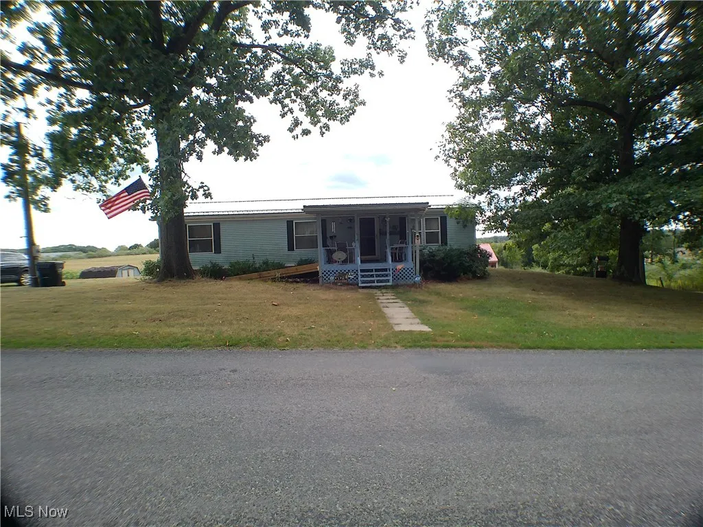 View of front of house with covered porch and a front yard