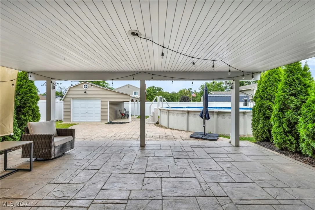 Fenced backyard featuring an outbuilding and a patio