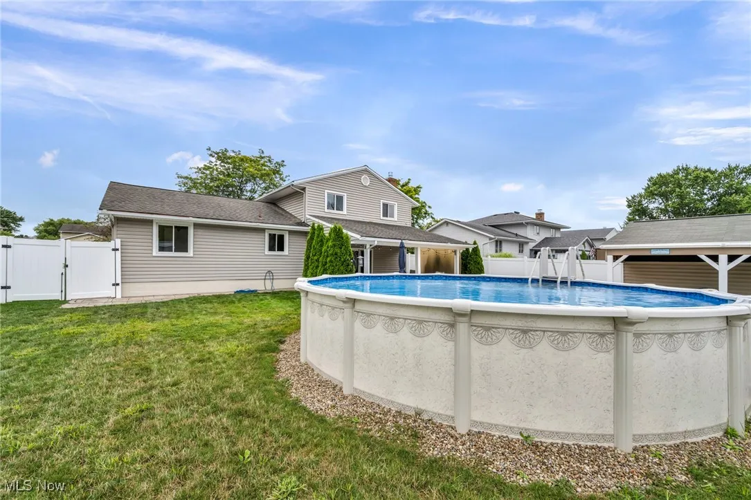 View of pool with a patio and a gate