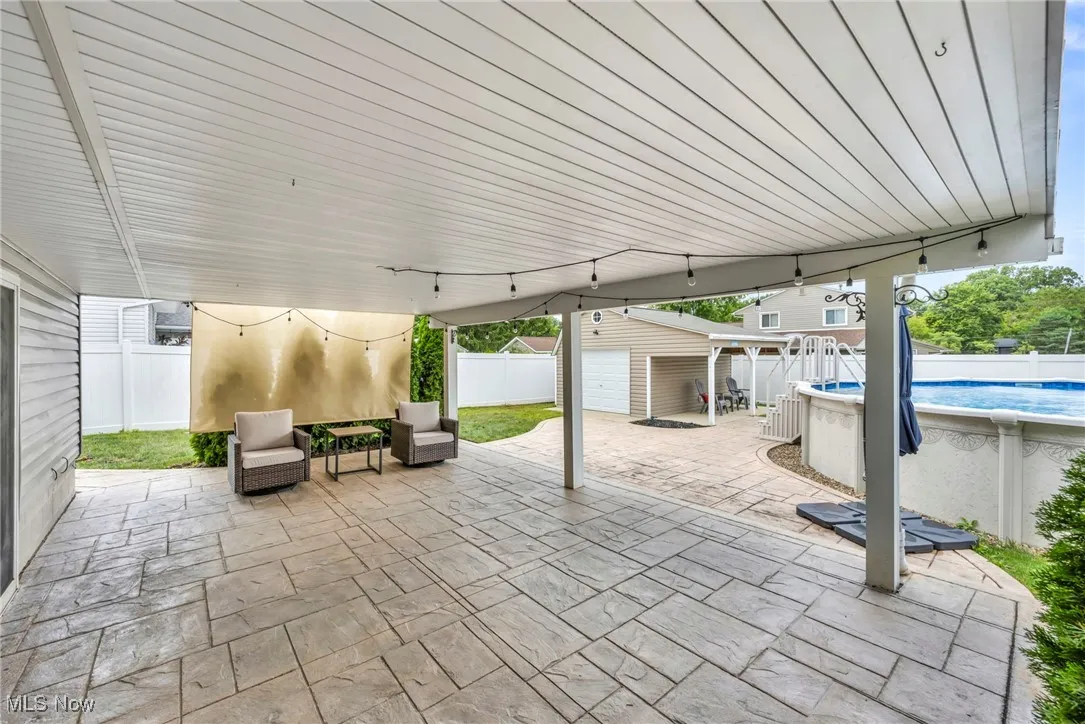 Fenced backyard with an outbuilding and a patio