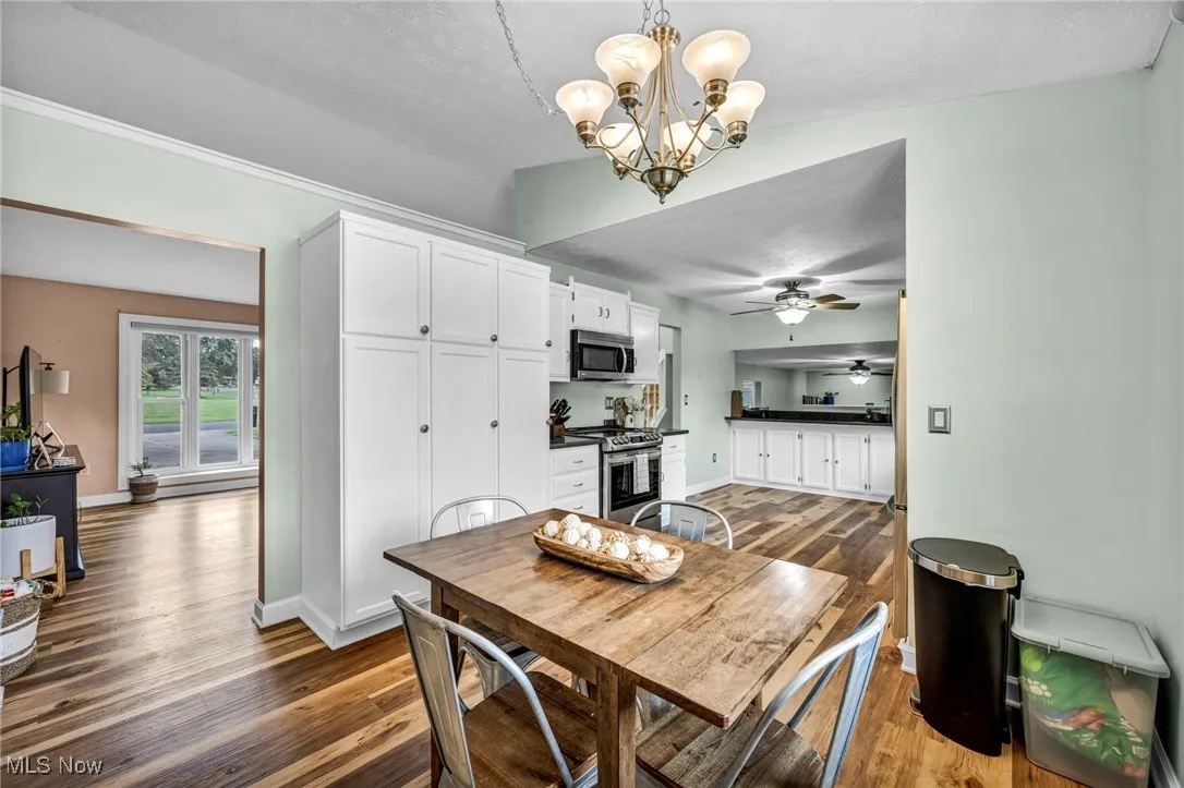 Dining space featuring a chandelier, wood finished floors, and a textured ceiling