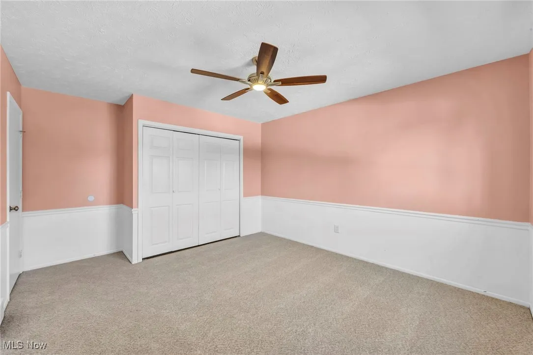 Unfurnished bedroom featuring carpet flooring, ceiling fan, a closet, and a textured ceiling