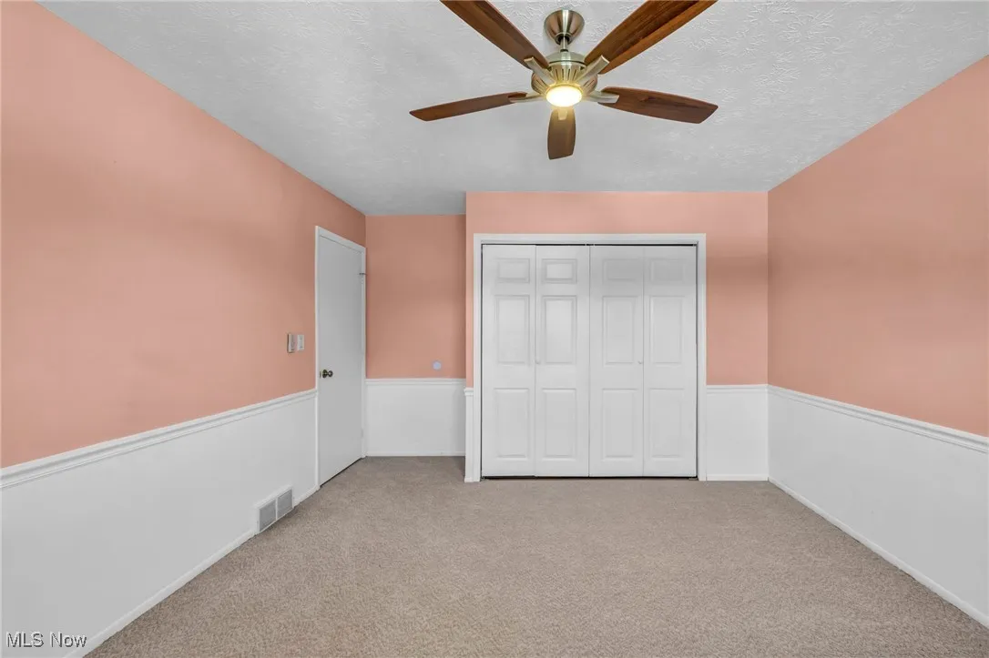 Unfurnished bedroom featuring carpet flooring, a ceiling fan, a textured ceiling, and a closet