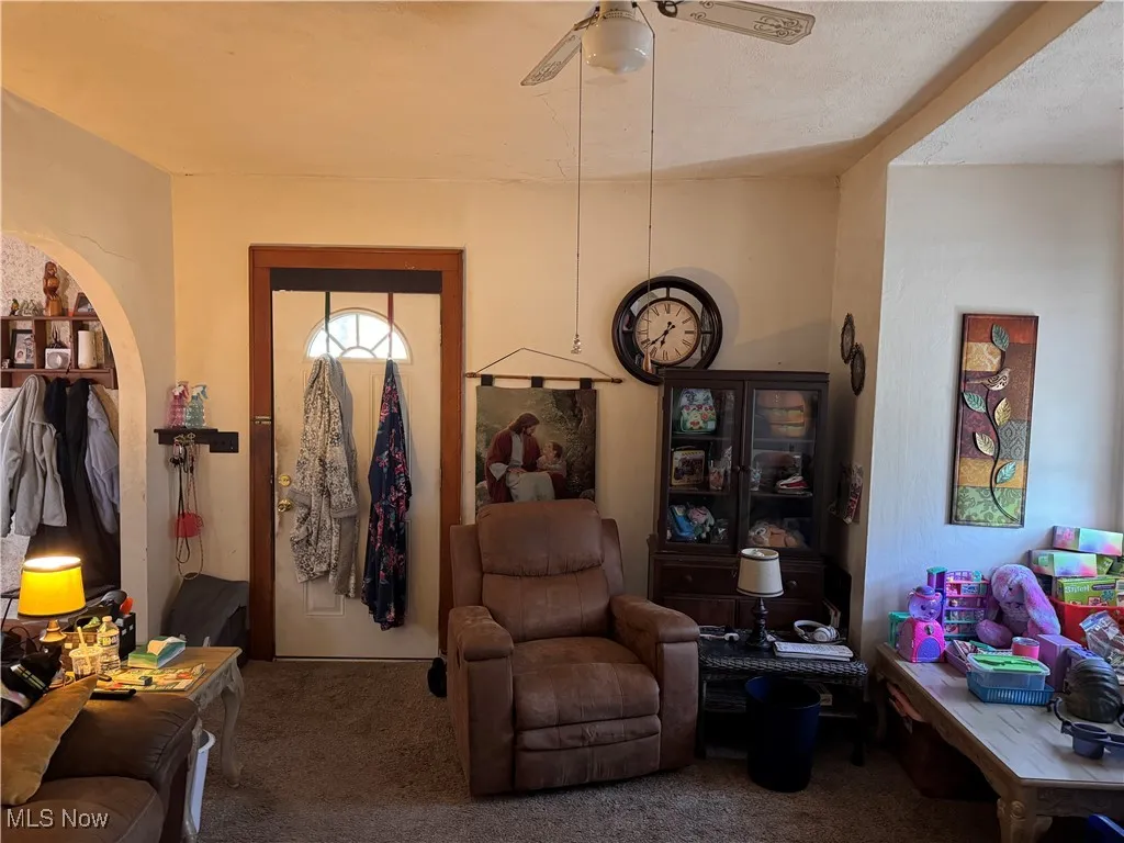 Living area featuring carpet flooring and ceiling fan