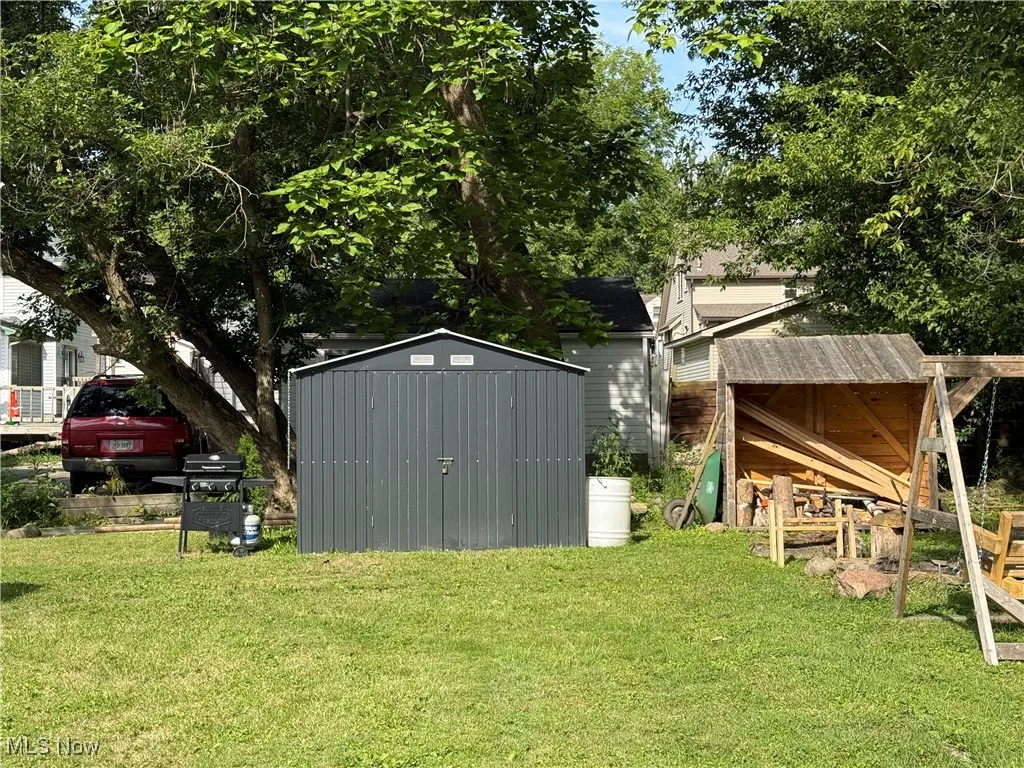 View of green lawn featuring a storage shed