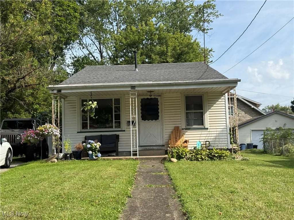 Bungalow-style home with roof with shingles, a porch, and a front lawn