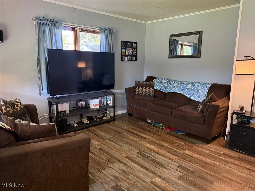 Living room featuring ornamental molding and wood finished floors