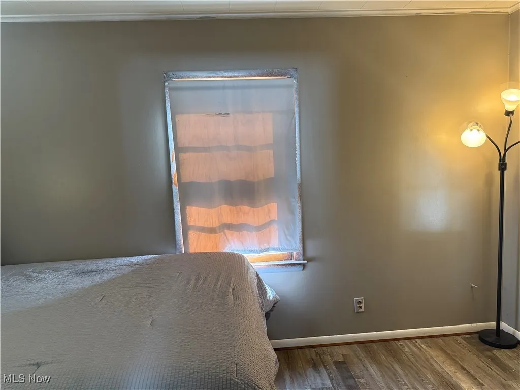 Bedroom with baseboards and wood finished floors