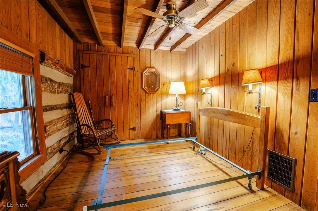 Workout area with wooden walls, wood ceiling, wood-type flooring, ceiling fan, and heating unit