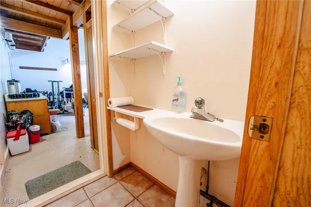 Bathroom with light tile patterned floors and baseboards