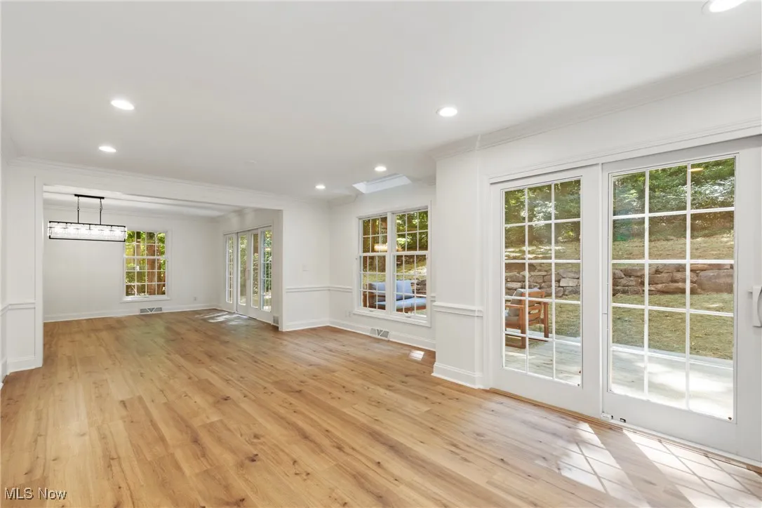 Unfurnished living room featuring recessed lighting, light wood-type flooring, and crown molding
