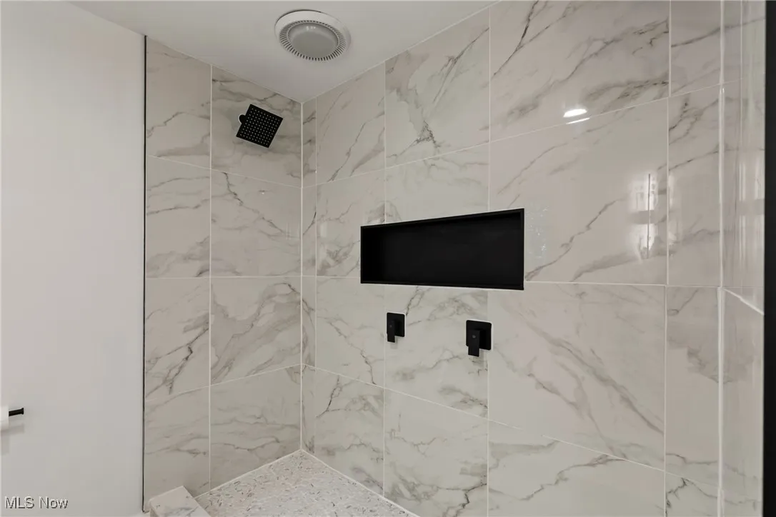 Bathroom featuring a marble finish shower