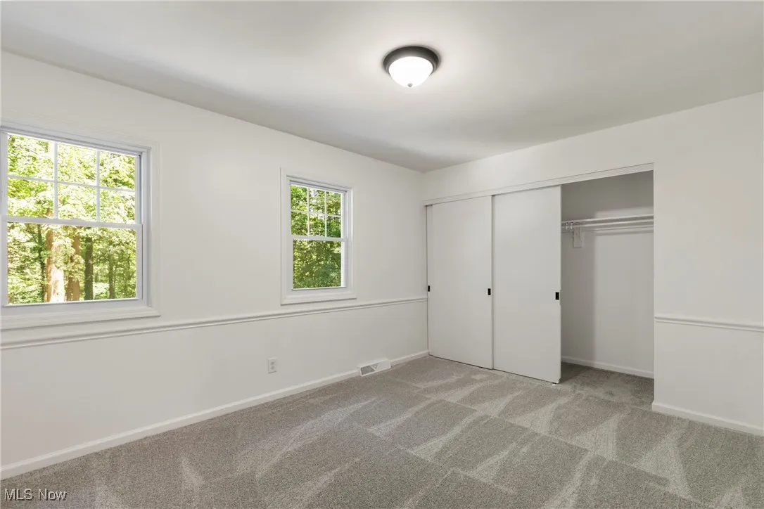 Unfurnished bedroom featuring light colored carpet and a closet