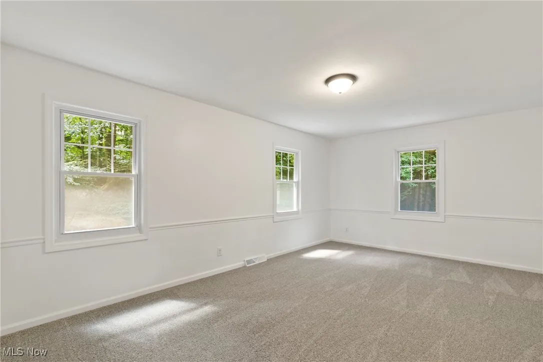 Carpeted empty room with baseboards