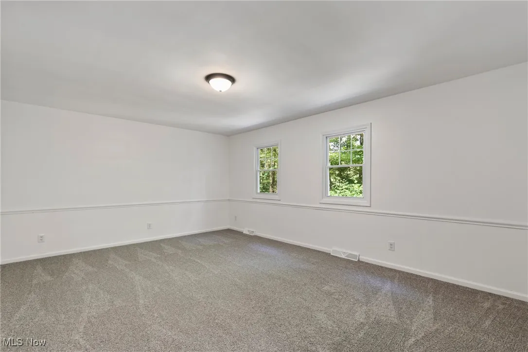 Carpeted empty room with baseboards