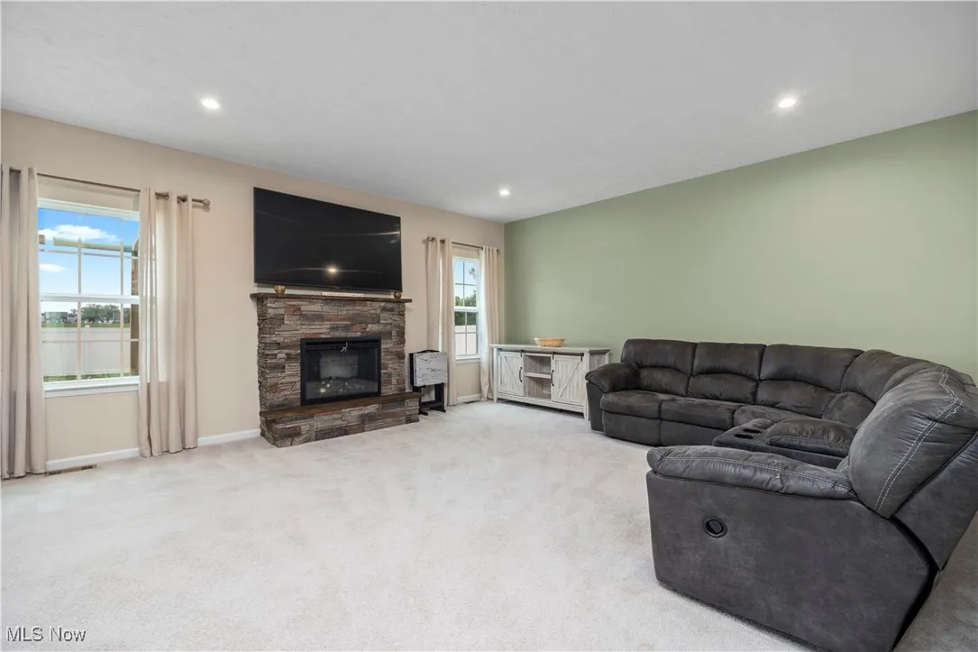 Carpeted living room with a fireplace and recessed lighting